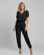 Erma V-Neck Jumpsuit met elastische taille in zwart, groen, blauw en geel.