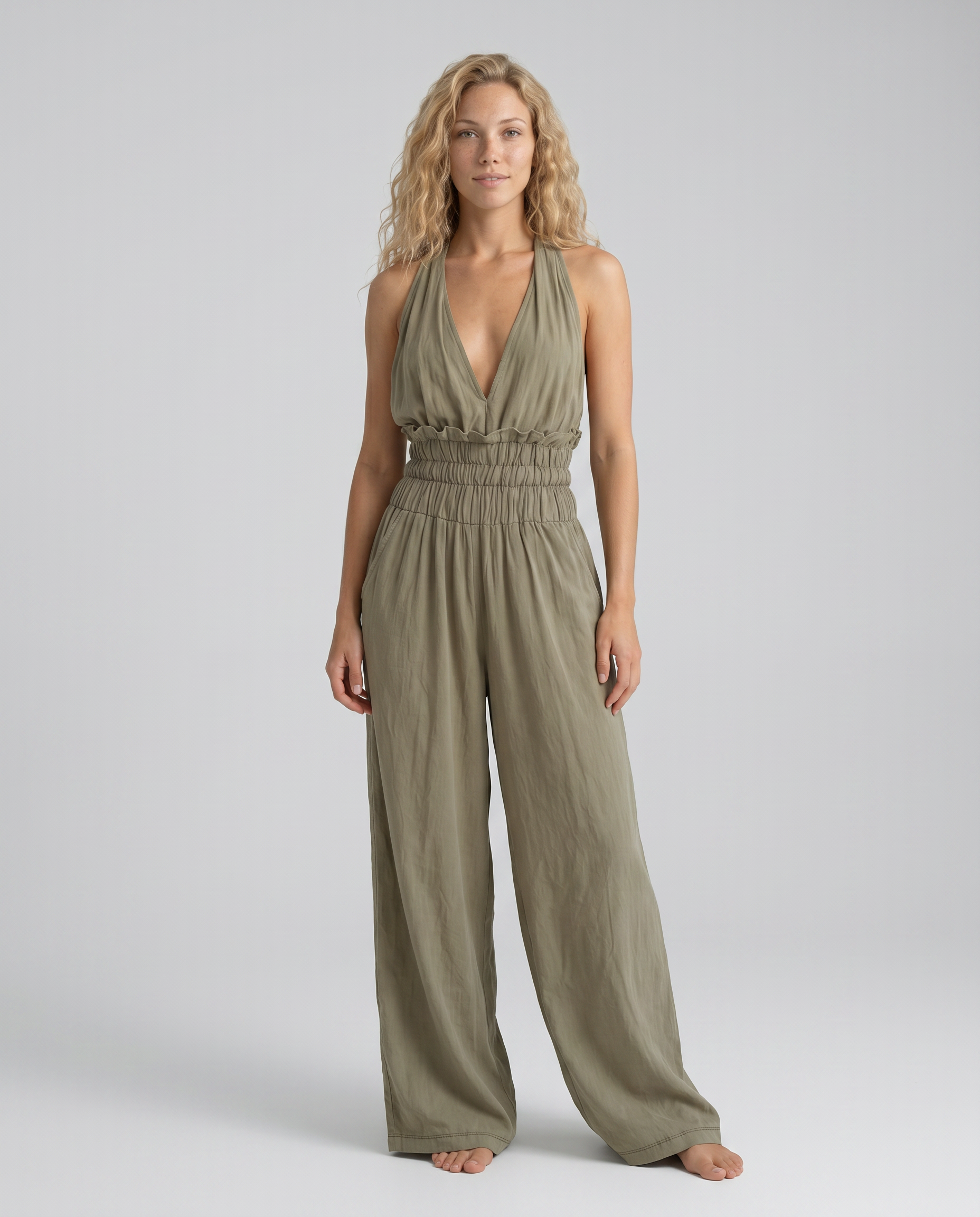 Elegante halter-neck jumpsuit in saliegroen met wijde broekspijpen.
